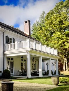 a large white house sitting on top of a lush green field