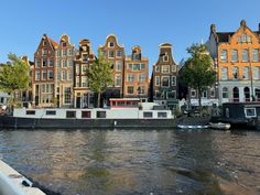 a boat traveling down a river next to tall buildings