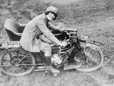 an old black and white photo of a man on a motorcycle with his hand on the handlebars