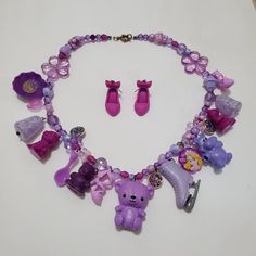 This is a purple themed charm necklace that I crafted out of vintage toys and charms. It is full of exciting variety and textures. Comes with matching earrings. Playful Purple Dangle Jewelry, Fun Purple Dangle Jewelry, Fun Purple Jewelry For Gifts, Playful Purple Necklaces For Gifts, Playful Purple Necklace For Gifts, Playful Purple Necklace For Gift, Whimsical Purple Necklace For Gifts, Whimsical Purple Necklace For Gift, Cute Handmade Purple Necklaces