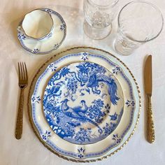 a blue and white plate sitting on top of a table next to silver utensils