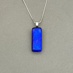 Cobalt Blue Dichroic fused glass Necklace. Handmade in West Yorkshire. Please note this listing is for the necklace only. Matching earrings available here; All pendants are handmade and unique, therefore patterns and colours may differ from the images shown. Dichroic glass has a transmitted colour and a completely different reflective colour; these two colours shift depending on the angle of view. This pendant has a Silver Plated glue on bail with the choice of different Sterling Silver or Silve Blue Minimalist Rectangular Pendant Jewelry, Handmade Blue Rectangular Necklace, Modern Rectangular Glass Jewelry, Blue Necklace With Large Rectangular Pendant, Blue Necklaces With Rectangular Stone For Gift, Minimalist Blue Necklace With Rectangular Pendant, Blue Necklace With Rectangular Stone For Gift, Modern Blue Rectangular Necklace, Glass Necklaces With Rectangular Pendant For Gift