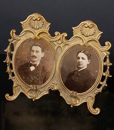 an old photo of two men with mustaches in gold frames on a black surface