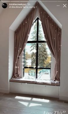 an open window with curtains in front of it and a car parked outside the window