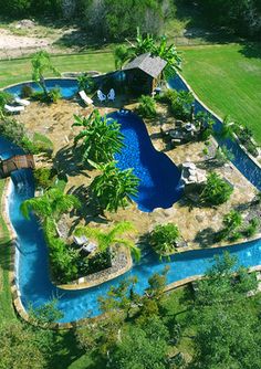 an aerial view of a pool surrounded by trees