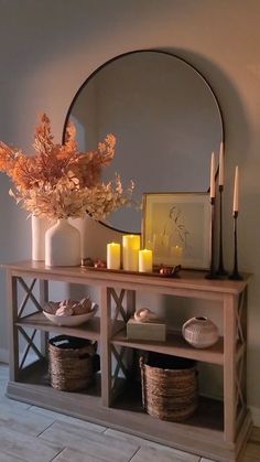 a vase with flowers and candles on a table next to a mirror that says love