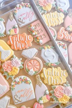 two trays filled with decorated cookies on top of a table next to each other