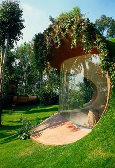 a sculpture in the shape of a curved tube with plants growing on it's sides