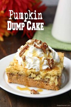 pumpkin dump cake on a white plate with whipped cream and pecans in the background