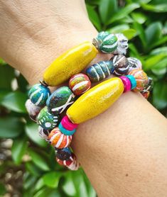 a woman's arm with two bracelets on it and some beads in the middle