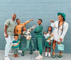 a family poses for a photo in front of a blue wall with their child's name written on it