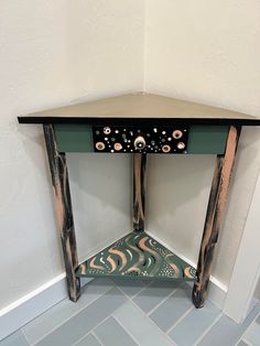 the corner of a room with a small table on it's side and tile floor