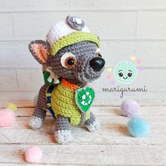 a crocheted mouse with a green hat and scarf on it's head