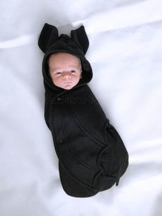 a baby is dressed in a black bear outfit with ears on it's head