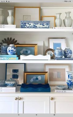 the shelves are filled with blue and white vases, pictures, and other decorative items