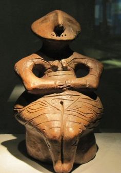 an old clay statue sitting on top of a table