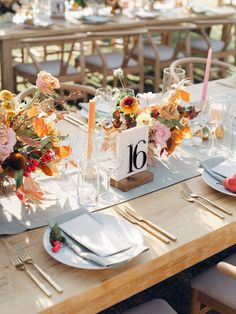 the table is set with flowers and candles