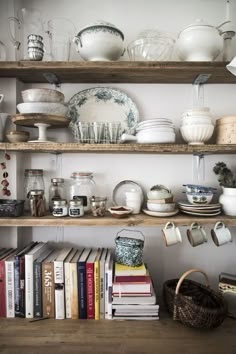 the shelves are filled with dishes and books