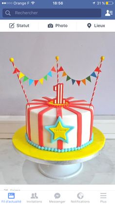 a birthday cake decorated with flags and stars on top of a table next to a cell phone