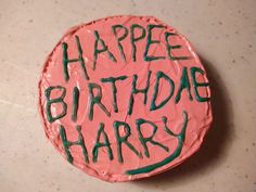 a birthday cake with the words happy birthday harry written in green frosting on it