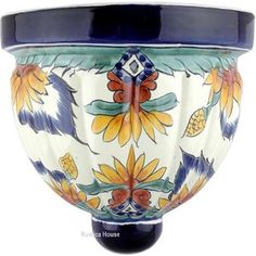 a blue and white vase with flowers painted on it