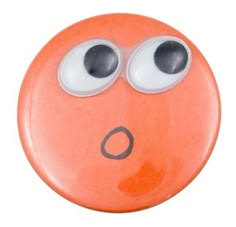 an orange button with googly eyes and one black eye on the bottom, is shown in front of a white background