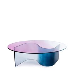 an oval glass table with blue, pink and purple colors on the top is against a white background