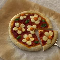 a pizza sitting on top of a piece of parchment paper next to a knife and fork