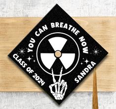 a black and white graduation cap that says you can breathe now