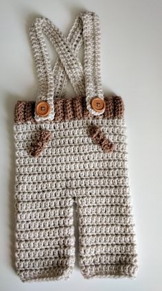 a crocheted baby's overall with buttons on the front and straps down