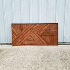 a large wooden door sitting on top of a cement floor next to a white wall