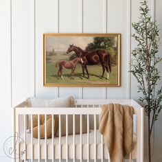 a horse and foal painting hanging on the wall above a crib