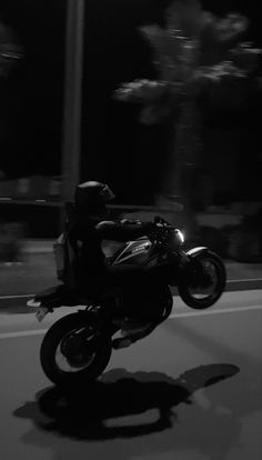 a person riding a motorcycle on the road at night