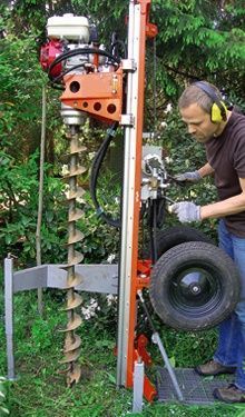 a man is working on a tire in the grass with headphones around his ears