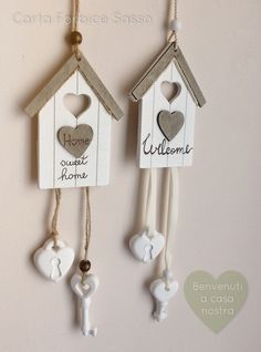 two birdhouses with hearts and key hangers attached to the side of each house