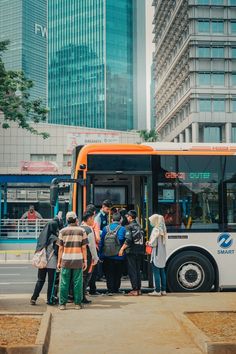 a group of people standing in front of a bus on the side of the road