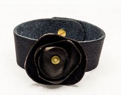 Trendy and chic, this beautiful cuff bracelet is handmade with genuine leather.  They make  perfect gifts for your female siblings: Christmas, Valentines day, Mother's day, birthdays, wedding anniversary.... or just because. Color : black  Size : Choose yours in the drop down menu. For any help you should send me a message. Care instruction : gently clean with soft and dry cloth. Avoid too much contact with water. This item is sent with tracking number 1 to 3 days after payment.  Happy shopping ! :) Find all my bracelets by clicking this link :  https://www.etsy.com/fr/shop/JULESetJADE?ref=seller-platform-mcnav&section_id=22374701 Follow me and my brand  :  https://www.facebook.com/julesetjade/ https://www.instagram.com/julesetjade/ Chic Handmade Bracelets As Gift, Unique Black Leather Bracelet For Gift, Handmade Flower-shaped Chic Jewelry, Chic Leather Bracelet Jewelry, Chic Adjustable Leather Bracelet, Handmade Cuff Bracelets As Gift, Unique Adjustable Leather Bangle Bracelet, Elegant Brown Cuff Bracelet Gift, Elegant Brown Cuff Bracelet As Gift