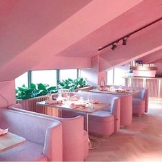 the interior of a restaurant with pink furniture