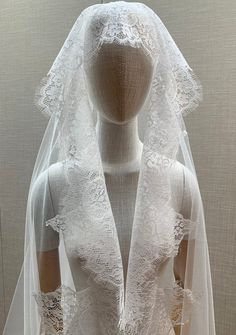 a mannequin wearing a wedding dress and veil