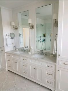 a large bathroom with double sinks and mirrors