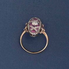 A classic Edwardian dinner ring, studded with rose cut diamonds and calibre cut pink sapphires. She spans across the top of the finger beautifully, giving you big flashes of color from the sapphires and subtle sparkle from those rose cuts. A beautiful ring to add a juicy pop of color to your collection of rings! Platinum & 18kt yellow gold Size 6.5 & resizable Center is estimated to be J/K color & Si2/I1 clarity Surrounding diamonds are estimated to be H/K color & VS/SI clarities Rubies are esti Luxury Pink Sapphire Ring With Rose Cut Diamonds, Oval Rose Cut Diamond Ring With Ruby Accents, Victorian Sapphire Ring With Diamond Oval Shape, Victorian Oval Sapphire Ring With Diamond, Victorian Ruby Ring With Diamond, Marquise Ruby Ring With Rose Cut Diamonds, Anniversary Pink Sapphire Ring With Rose Cut Diamonds, Victorian Pink Rose Cut Diamond Jewelry, Victorian Ruby Ring With Single Cut Diamonds