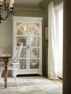 a white china cabinet sitting in the corner of a room