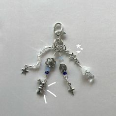 Handmade wire-wrapped silver and blue astronaut space keychain, perfect for space enthusiasts. This unique, celestial-themed keychain features an intricately crafted astronaut design. The combination of silver and blue colors adds a touch of cosmic beauty. A must-have accessory for space lovers and a great gift idea. Explore the wonders of the universe with this space-inspired, artisan keychain, reminiscent of space exploration and sci-fi adventures. Silver Keychain Aesthetic, Wrapped Keychain, Galaxy Keychain, Astronaut Keychain, Space Keychain, Space Lovers Gifts, Keychain Blue, Ethereal Jewelry, Diy Kandi Bracelets