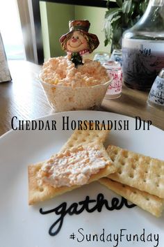 cheddar horseradish dip and crackers on a white plate with the words gather next to it