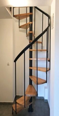 a spiral staircase with wooden steps in an empty room