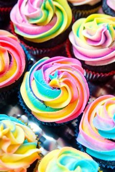 there are many cupcakes with different colored frosting