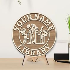 a wooden sign that says your name library with flowers in the center on a stand