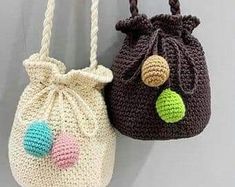 two crocheted purses hanging on a wall next to each other, one with a ball