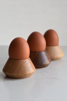 three brown eggs sitting on top of each other in front of a white countertop