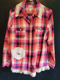 This Old Navy 'Plaid' size Large shirt in pink, white & navy is trimmed with woven ivory lace at the hem and collar and features decorative stitching, a hand crochet round lace accent with a gold-tone pin with pink accents. Per the ON size chart, bust is 39"-41", waist is 31.5" to 33.5" As my items are upcycled, one-of-a-kind creations, multiple sizes are not offered. Fall Cotton Tops With Lace Trim, Fitted Cotton Shirt With Lace Trim, Long Sleeve Cotton Shirt With Lace Trim, Cotton Long Sleeve Shirt With Lace Trim, Casual Button-up Shirt With Lace Trim, Collared Cotton Top With Lace Trim, Cotton Button-up Tops With Lace Trim, Cotton Button-up Shirt With Lace Trim, Cotton Lace Trim Button-up Shirt